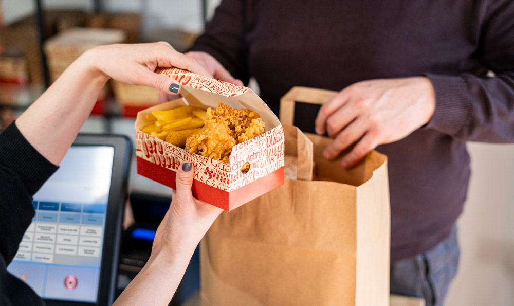 caja de pollo mano dos personas en una restauración que tienen caja de pollo