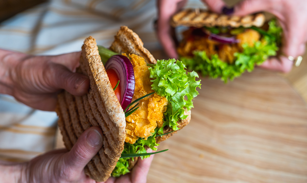 una tostada con pollo empanado y verduras crujientes