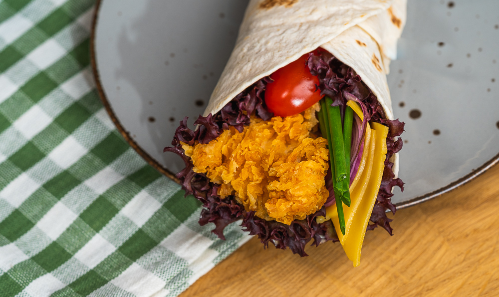 wrap de pollo y verduras en un plato de cerámica