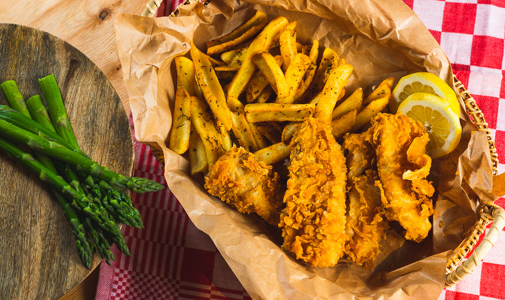 un plato con merluza rebozada y patatas fritas