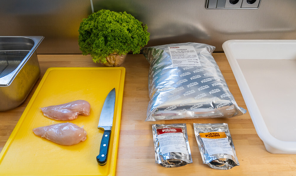 una mesa en la cocina preparada para hacer pollo empanado