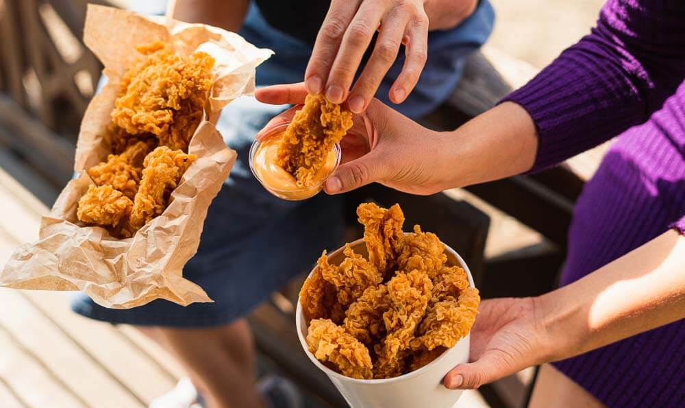 tiras de pechuga de pollo dos personas con tiras en las manos