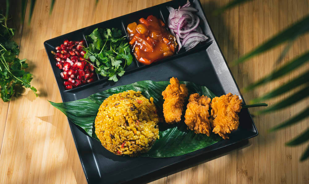un plato asiático con arroz y pollo en una hoja