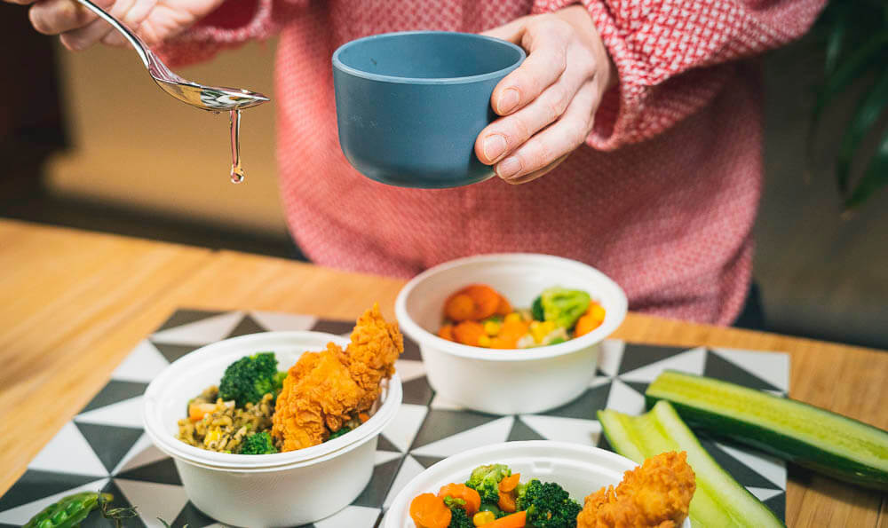 tres escudillas con porciones de arroz con pollo y aderezos