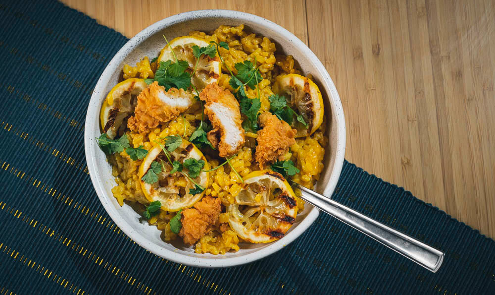 cuenco lleno de arroz amarillo con pollo y limón tostada
