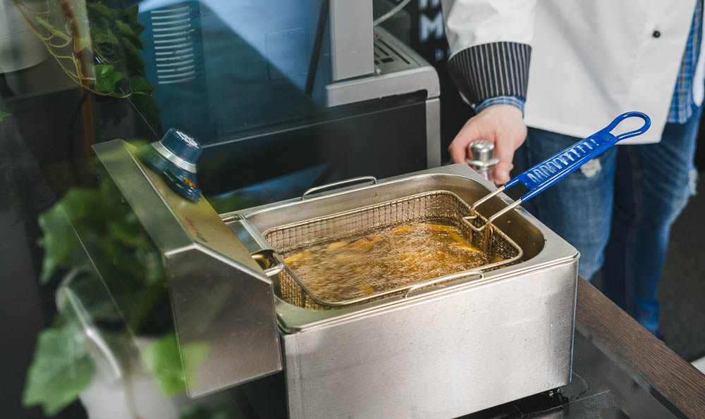 un cocinero con una freidora en una cocina